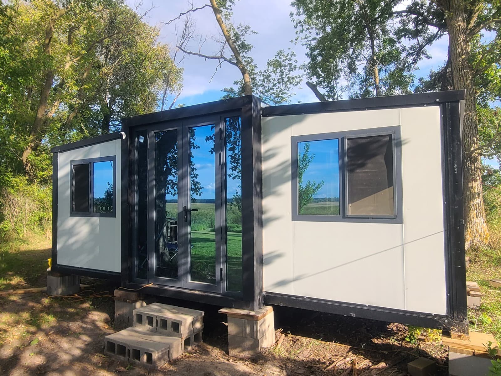Delivered white expandable home set on a rural property.