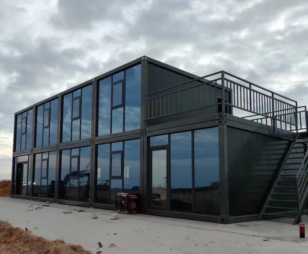 Dark modern modular office building with a rooftop deck.