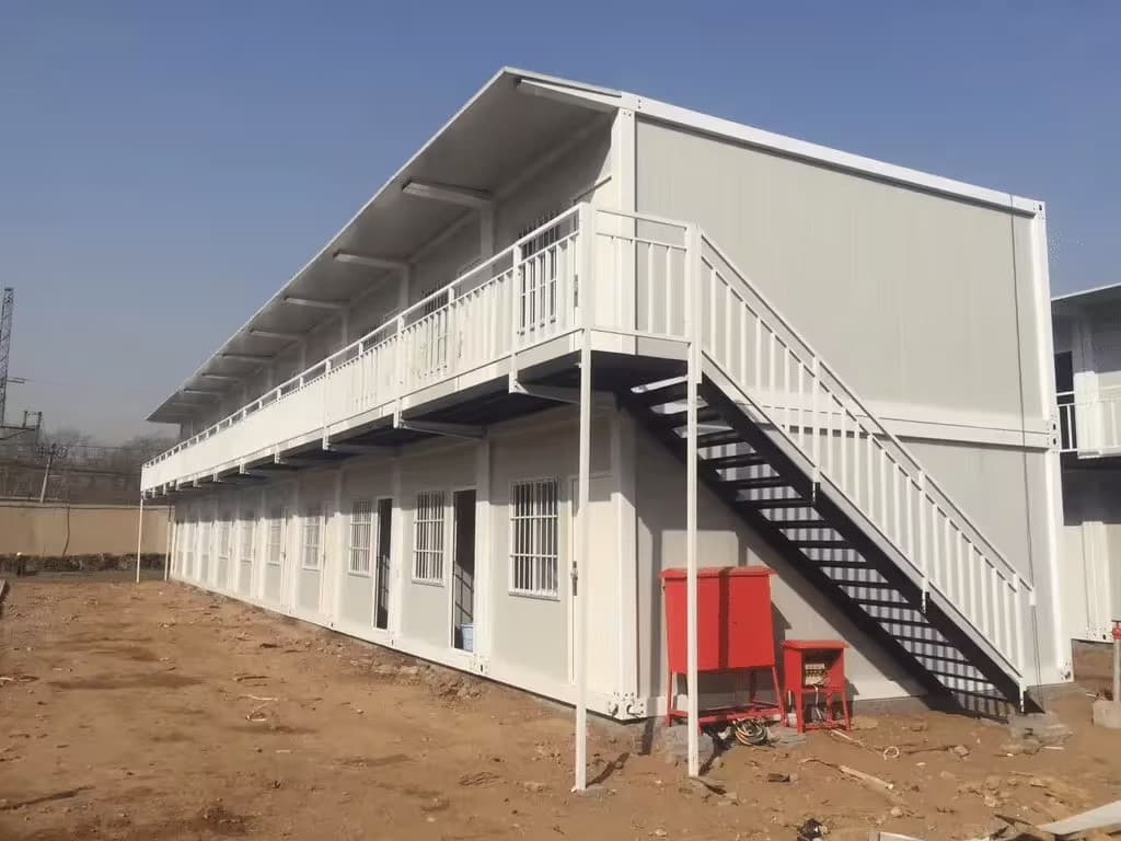 Long two-story modular residential building with an external staircase.