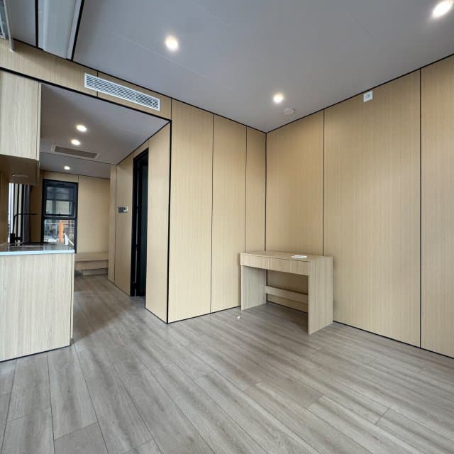 Apple Cabin interior with wood-paneled walls, a desk, and kitchenette.