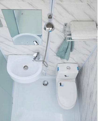 Inside the bathroom pod from above: corner basin, mirror, hand shower, towel rail and toilet.