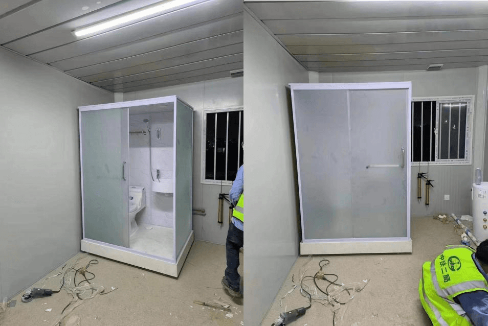 A bathroom pod being installed inside a steel modular unit, shown open and with its sliding door closed.