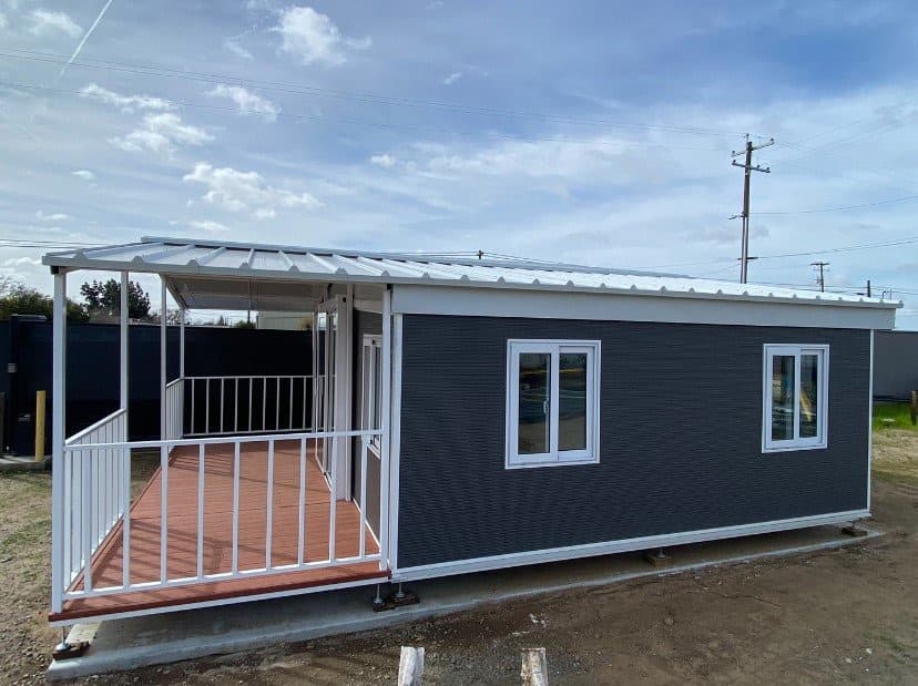 Gray 20x20 expandable home with a covered porch, side view.
