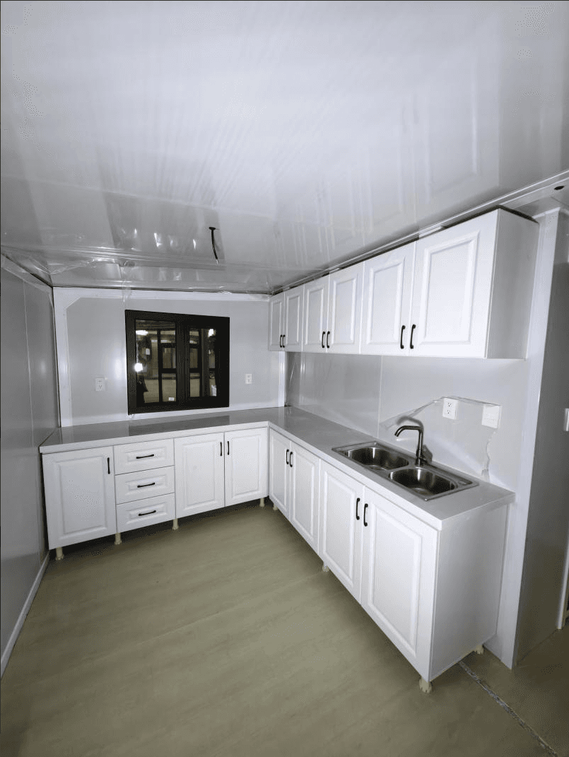 White kitchen cabinetry with countertop and sink.