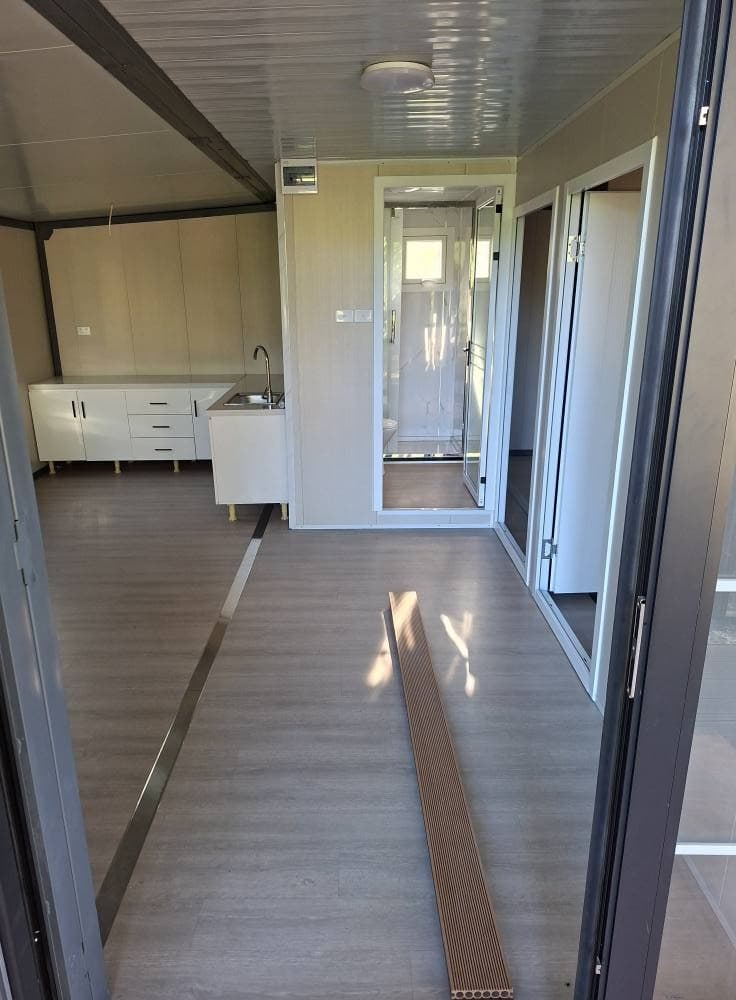 Expandable interior with kitchen and bathroom, wood-tone walls.