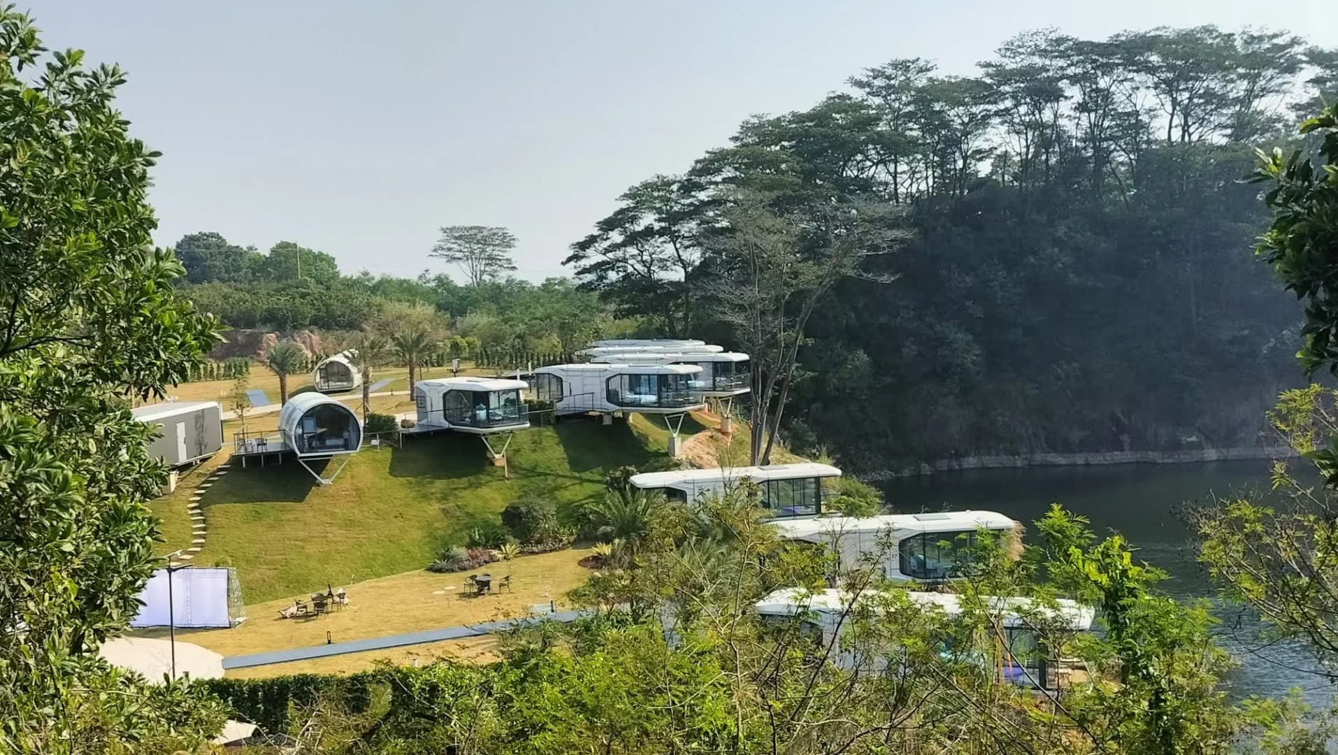 Aerial view of a Space Capsule pod village by the water.