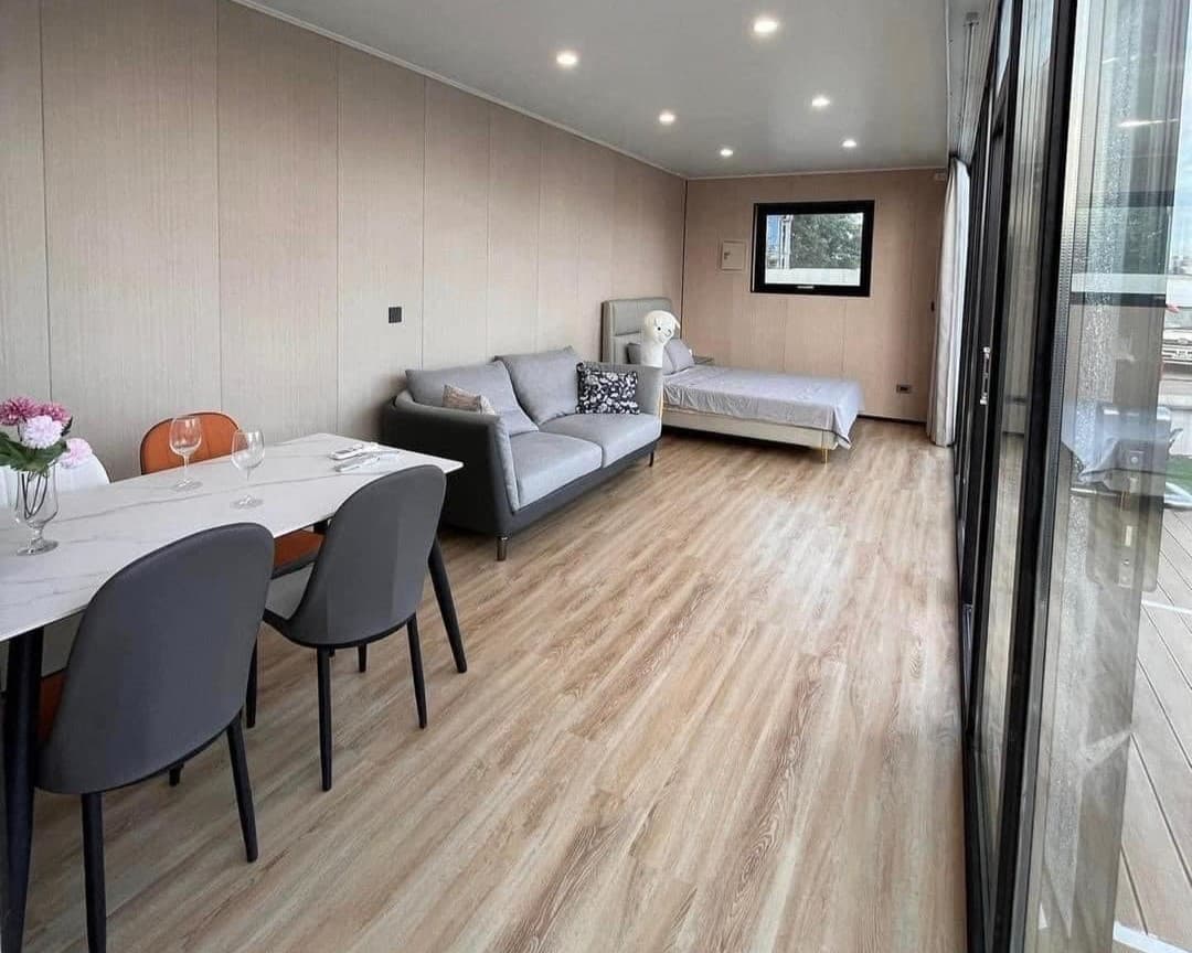 Furnished Space Capsule interior with dining, sofa, and bed.